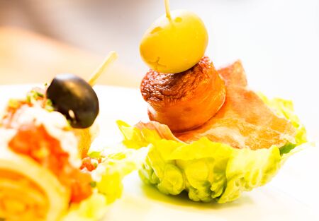 delicious pinchos with olives on salad leafの写真素材