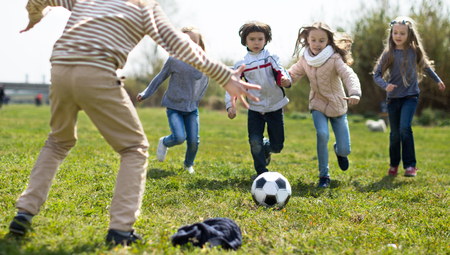 funny Children play with ball outdoors in springの写真素材