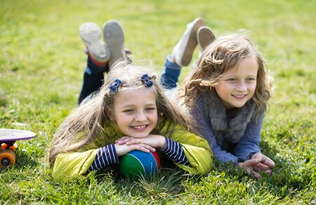 children enjoy lying on the grass in the parkの写真素材