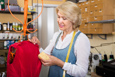 professional Female tailor working near mannequin in sewing workshopの写真素材