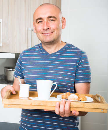 guy in striped shirt made breakfast for his wifeの写真素材