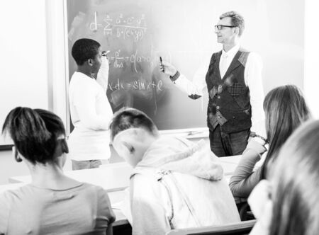 Aframerican schoolboy, answers near blackboard at math lessonの写真素材