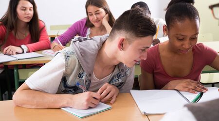 European student write off from notebook Aframerican studentgirl in classroomの写真素材