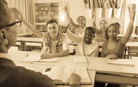 smiling students pull hands on lesson at collegeの写真素材