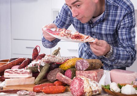 Ordinary man posing with a plate of cold cutsの写真素材