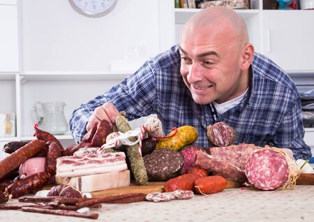 portrait of ordinary men with lots of meat and sausage productsの写真素材