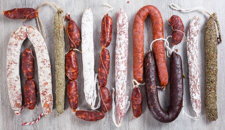 row of delicious sausages laid out on wooden baseの写真素材