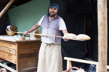 baker man posing with shovel and grain doughの写真素材