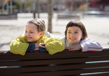 happy children posing on street bench in Indian summerの写真素材