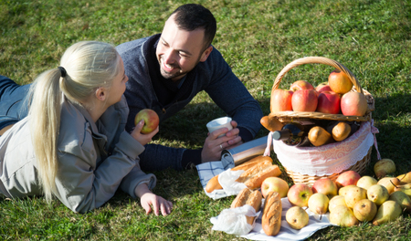 woman and man lounging in sunny spring day at picnic outdoorsの写真素材
