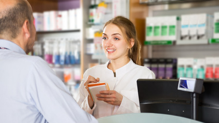 pharmacist and pharmacy technician posing in drugstoreの写真素材
