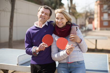 portrait of Happy mature couple with rackets for table tennisの写真素材