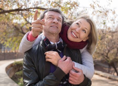 Mature family couple staying outdoor at fall day and smilingの写真素材