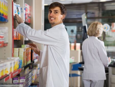 Portrait of two professional pharmacists working in modern farmacyの写真素材