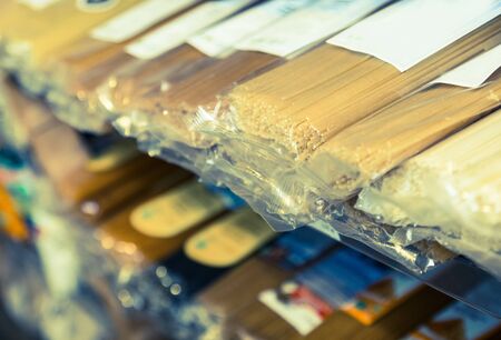 spaghetti in plastic packaging on store shelvesの写真素材