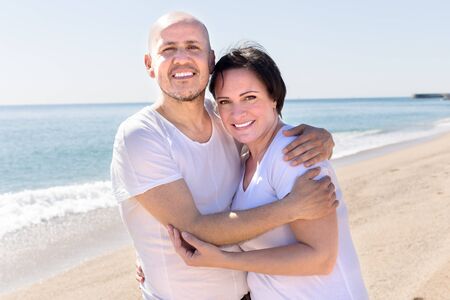 smiling mature man and female near seaの写真素材