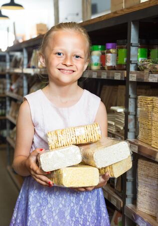 blonde girl posing with cookies in supermarketの写真素材