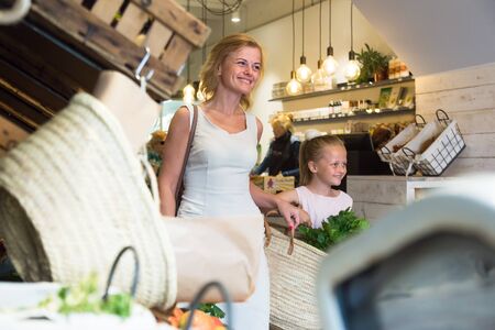 young mother with daughter buy corn cakes in storeの写真素材