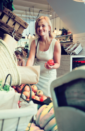 young blonde woman housewife in supermarketの写真素材
