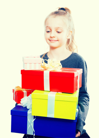 happy child with a lot of gift boxes in hands on isolated backgroundの写真素材