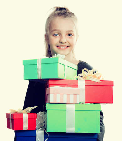 portrait of blonde girl holding in hands lots of boxes with gifts on isolated backgroundの写真素材