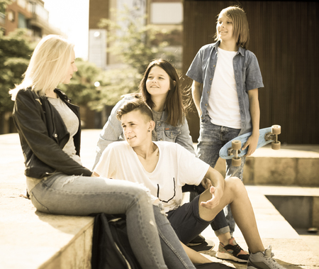 group of teenagers communicate in schoolyard