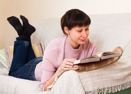 Woman reading a book at homeの写真素材