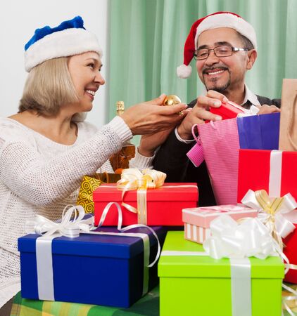 Smiling persons packed Christmas gifts at homeの写真素材