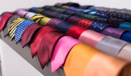 row of Neckties on hangers in men clothing storeの写真素材