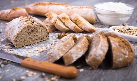 Fresh grain bread in a cut on a wooden tableの写真素材