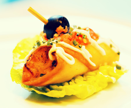 Exquisite pincho roll with olives on salad leafの写真素材