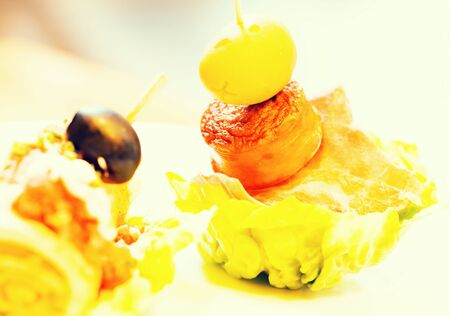delicious pinchos with olives on salad leafの写真素材