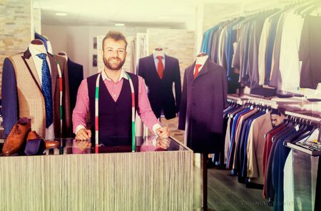 Portrait of male designer which is standing on workplace in men shop.の写真素材