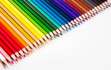 colored pencils lying in row on white backgroundの写真素材