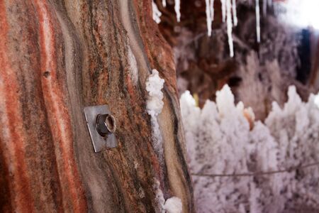 jumper in natural grotto at cave with white  natural stalactitesの写真素材