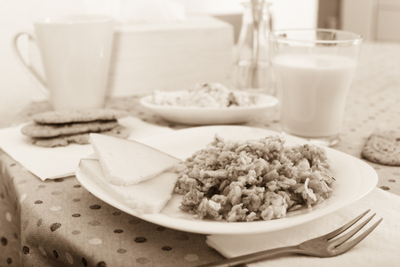 porridge from flakes of different varieties of grain, cheese and milk for healthy breakfastの写真素材