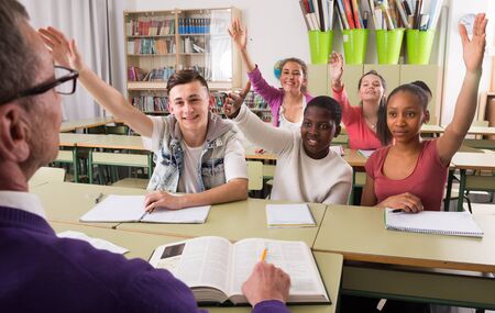 smiling students pull hands on lesson at collegeの写真素材