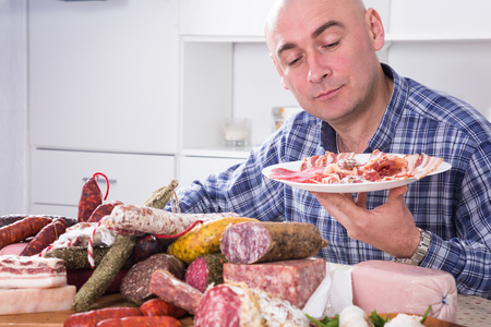 ordinary man posing with a plate of cold cutsの写真素材