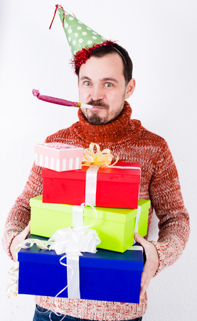 Portrait of Man on holiday in hat and whistle with giftsの写真素材