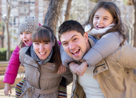 Happy family with two daughters outdoors in sunny fall dayの写真素材