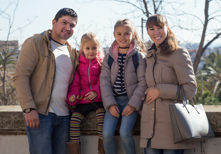 Happy smiling family with two girls outdoors in sunny fall dayの写真素材