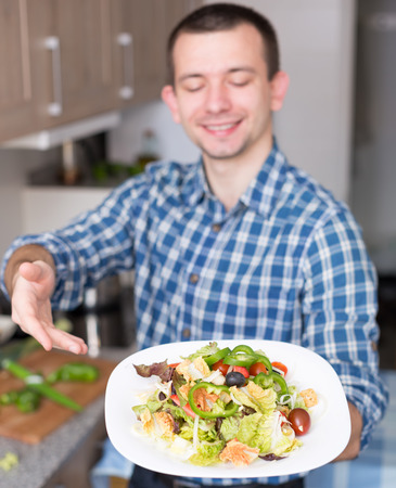young smiling guy cooked gourmet saladの写真素材