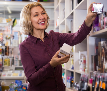 mature female offering cream in the store cosmeticsの写真素材