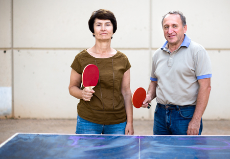 portrait of elderly posing couple with rackets for table tennisの写真素材
