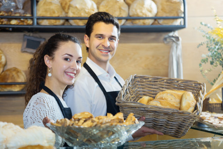 Happy italian couple enjoying selling fresh made bread at local bakery to customers
の写真素材