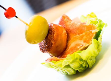 delicious pincho with olives on salad leafの写真素材