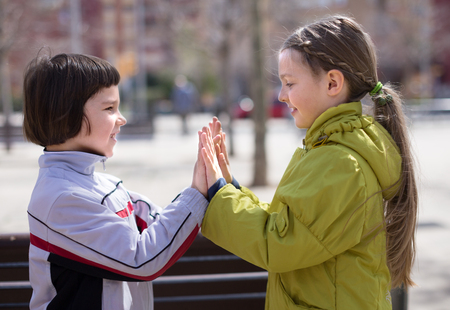 ordinary children clap outdoors in autumnの写真素材