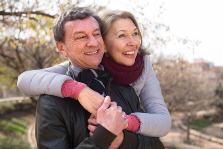 Happy smiling mature couple together in autumn parkの写真素材