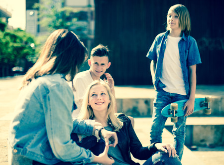 group of teenagers communicate in schoolyard