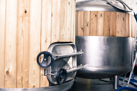 Steel barrels with wood trimmed for beer fermentation lined in production hallの写真素材